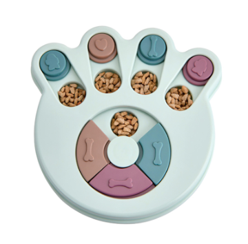 Blue paw-shaped dog feeding puzzle with pastel sliding covers, shown with dry food for demonstration