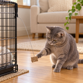 Grey cat batting Cat Dancer Pro clipped to a wire crate