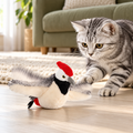 Silver tabby playing with flapping plush woodpecker on apartment floor