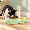 Black-and-white cat using the green Marchul feeding station