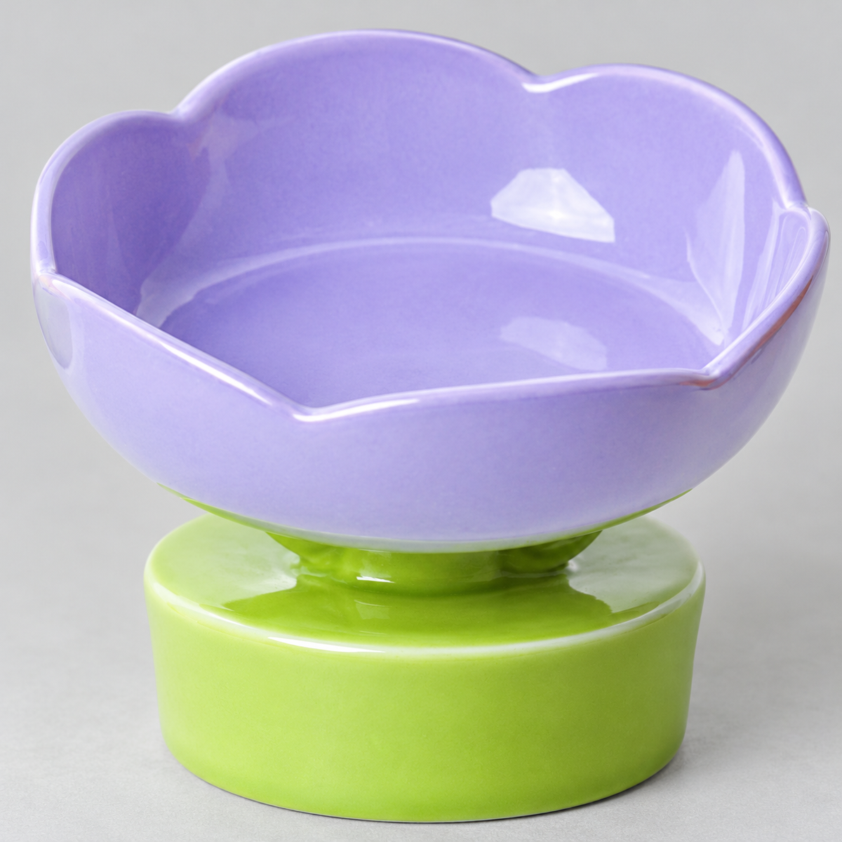 Close-up of the scalloped purple ceramic rim and green pedestal