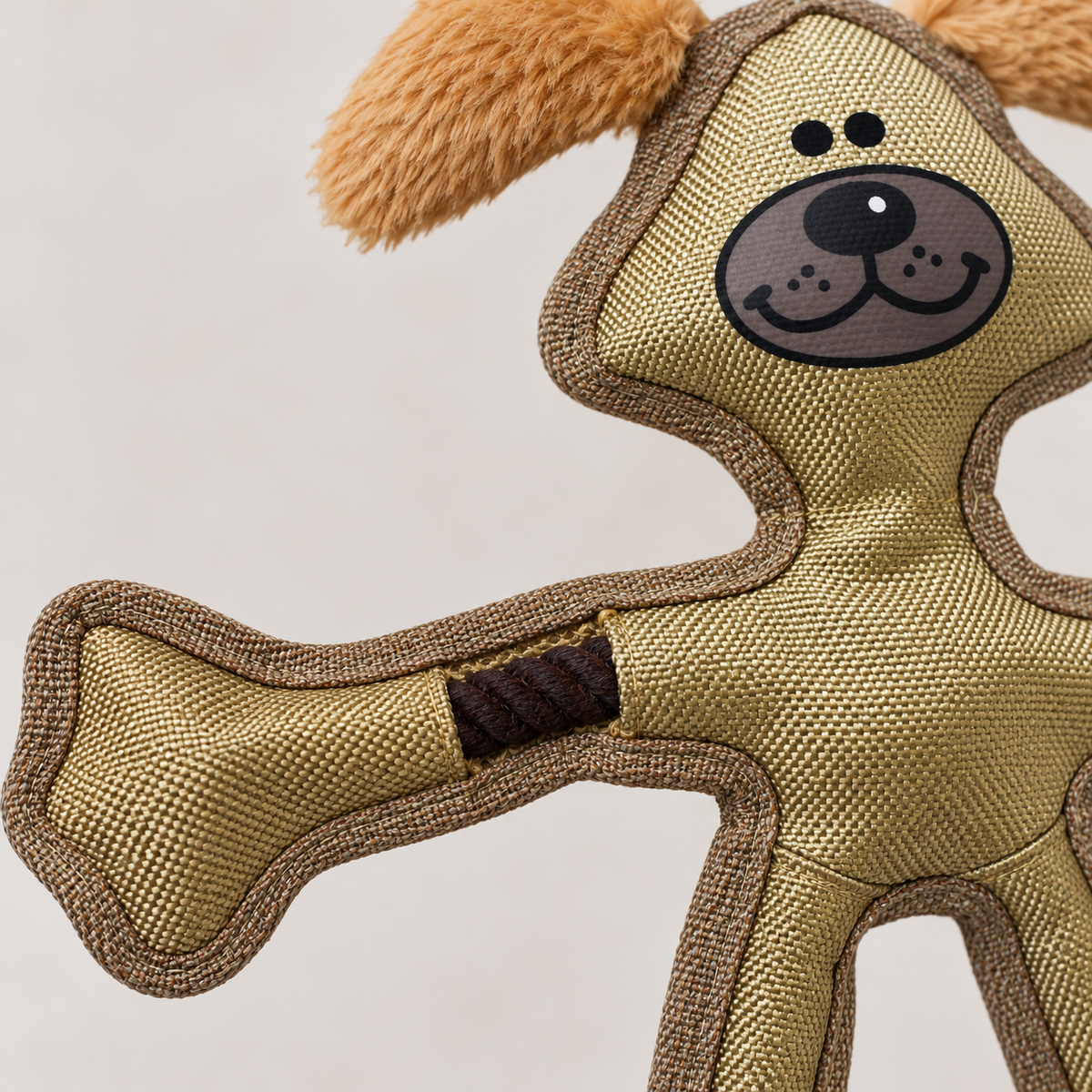 Close-up of the tan Skele-Ropes toy's nylon fabric, brown binding and exposed rope at the arm joint