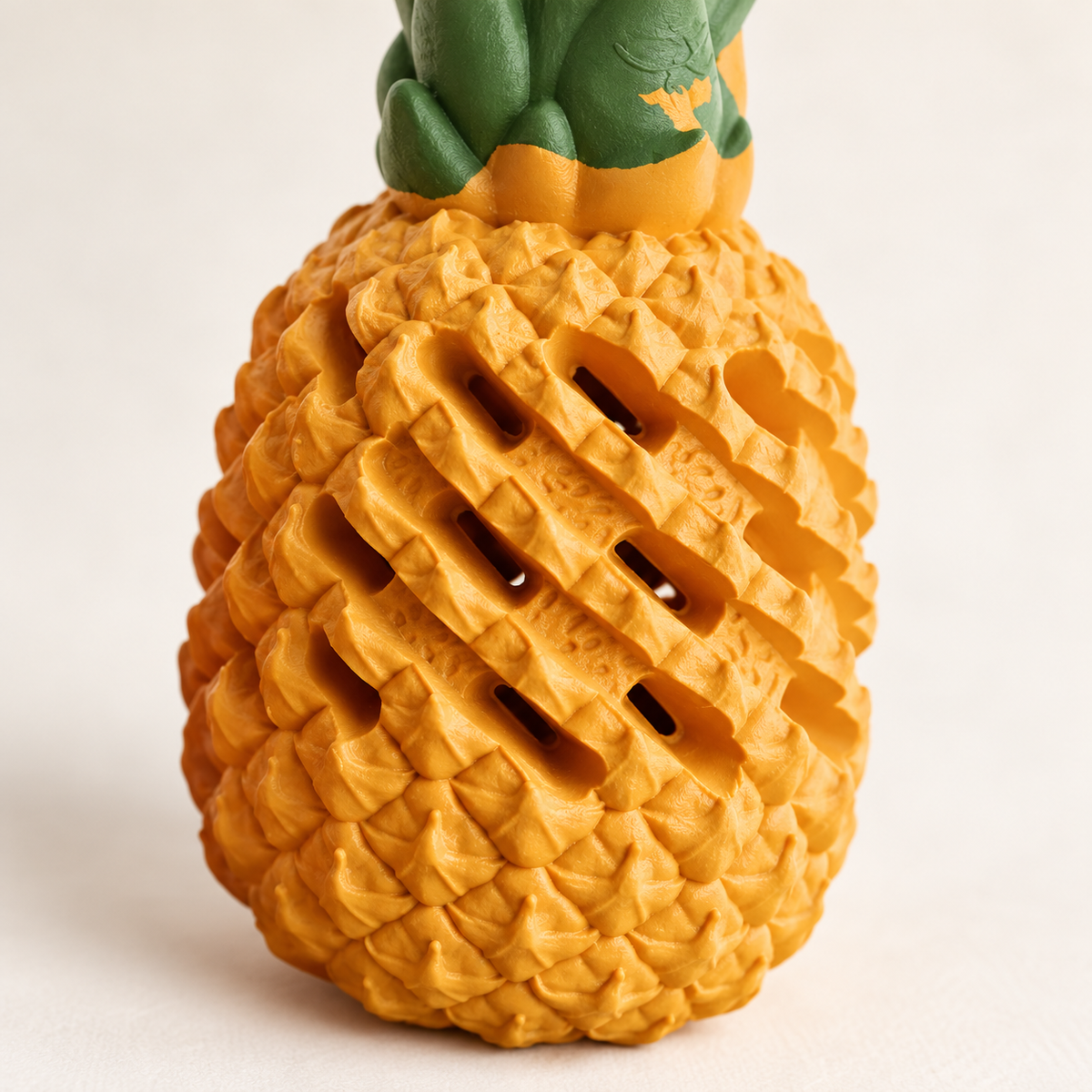 Close-up of the yellow pineapple dog toy's raised rubber texture and diagonal openings